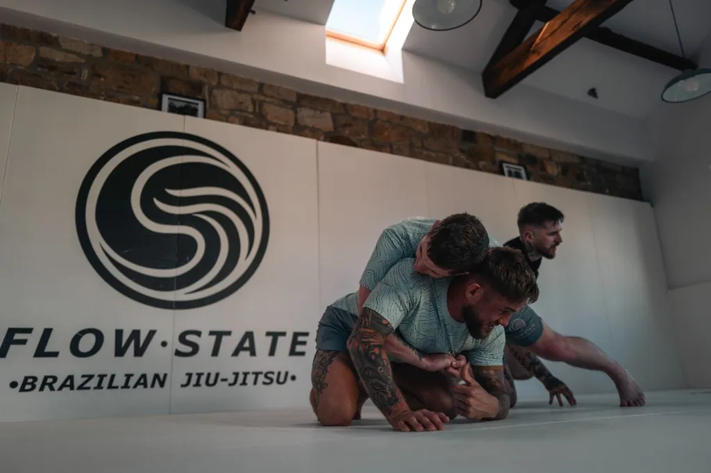 Two students rolling during live sparring at Flow State BJJ.